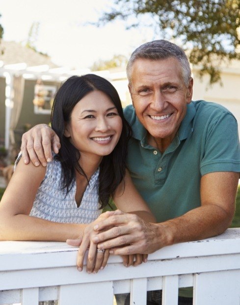 Husband and wife smiling outside