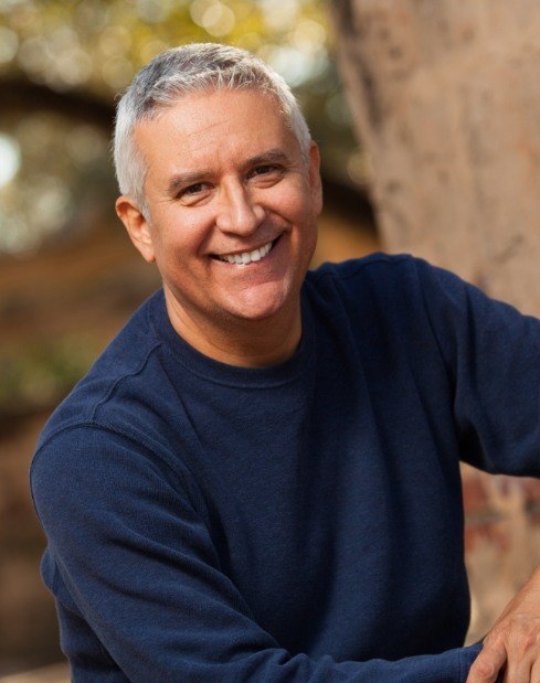 Man smiling outside by tree after restroative dentistry