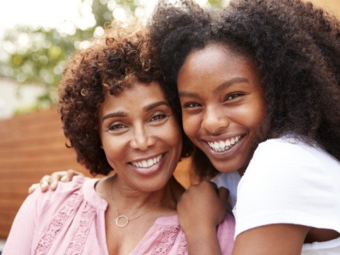 Grandmother and granddaugher smiling after dental checkup and teeth cleaning for kids