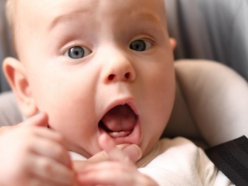 Dentist examining baby's smile beofre frenectomy for lip and tongue tie