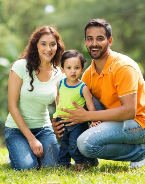 Family of three smiling after visiting their health first colorado and medicaid dentist