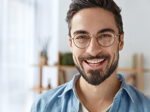 Man smiles after getting a dental crown in Denver