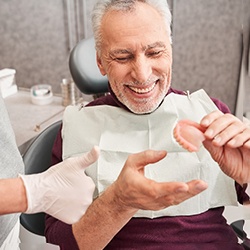 A dentist showing dentures to a senior patient