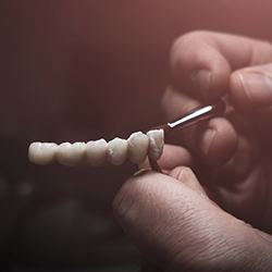 Technician painting artificial teeth