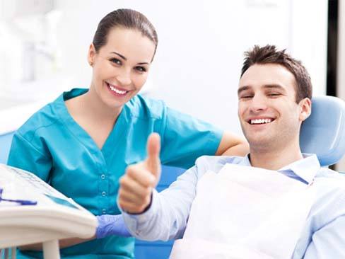 Emergency dentist in Denver smiling with a patient