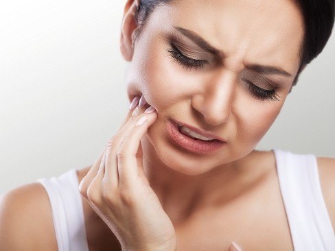 Woman in pain before dental services holding her cheek