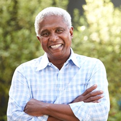 Man with dental implants in Denver, CO with arms folded
