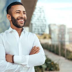 Man in white collared shirt smiling outside