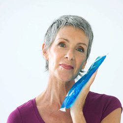 Senior woman about to use an ice pack on jaw