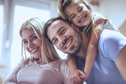 Parents and child smiling after family dentistry visit