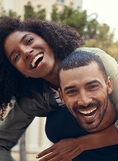 Man giving woman piggyback ride after dental care