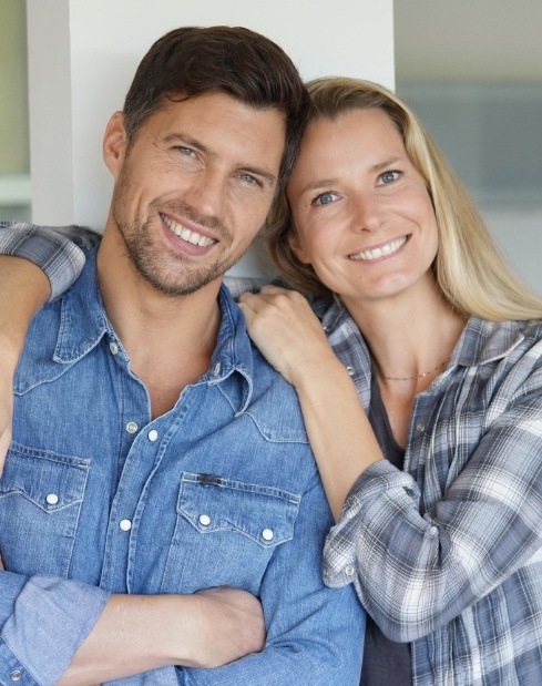 Man and woman smiling together after visiting the dentist