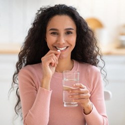 a woman taking an oral conscious sedation pill