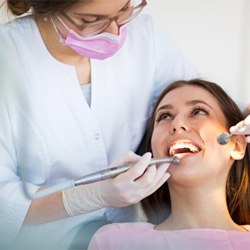 a patient getting her teeth checked by her dentist