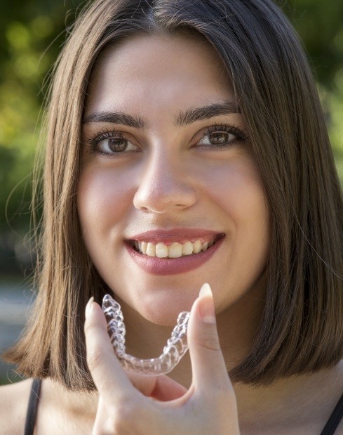 Woman holding invisalign tray