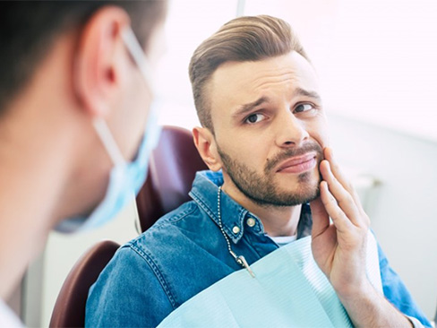 Woman smiling giving thumbs up in dental chair