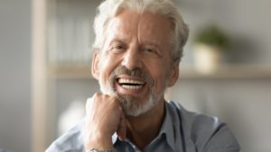 a man smiling with his dentures securely in his mouth