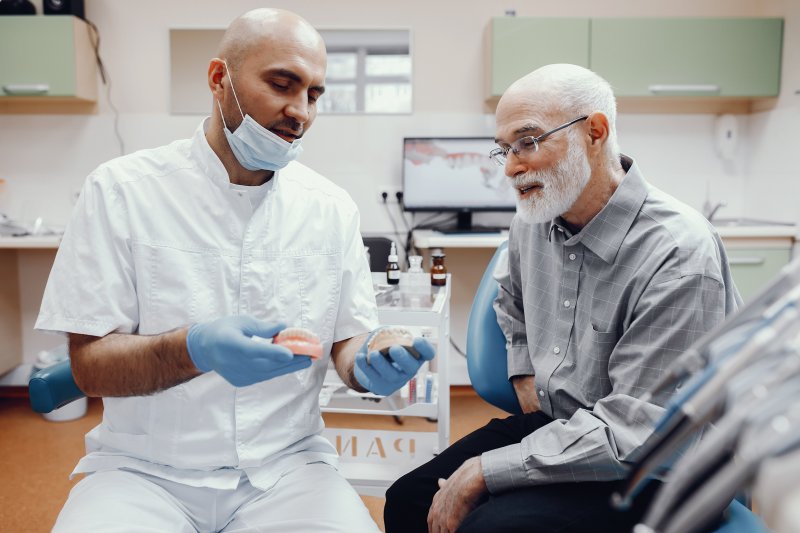 A dentist explaining tips for talking with dentures to a patient