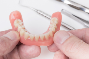 a closeup of hands holding a pair of dentures