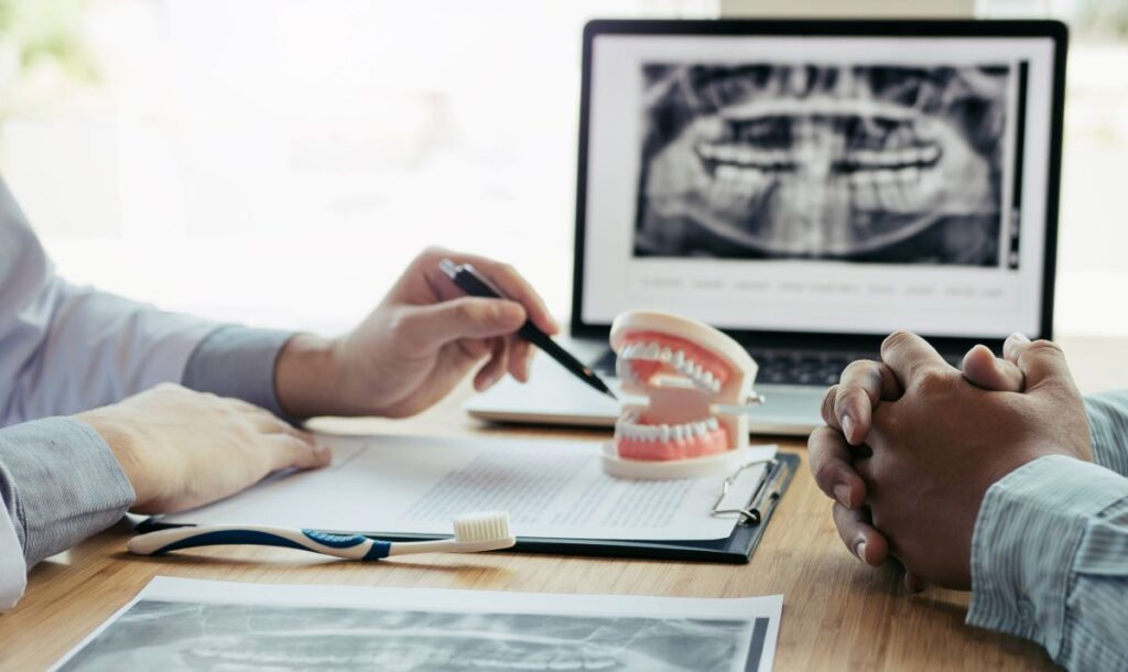 A dentist showing a patient a model of a mouth